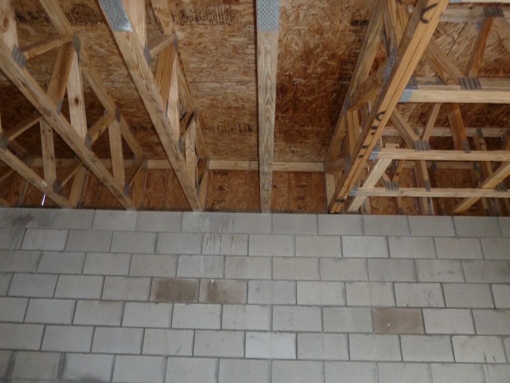 Prefabricated wood floor trusses over CMU support wall